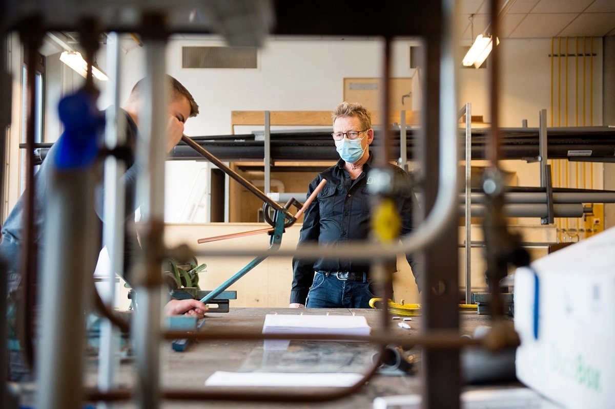 Praktijkbegeleider Theo van den Elzen laat Guus vast kennismaken met het mooie installatievak.